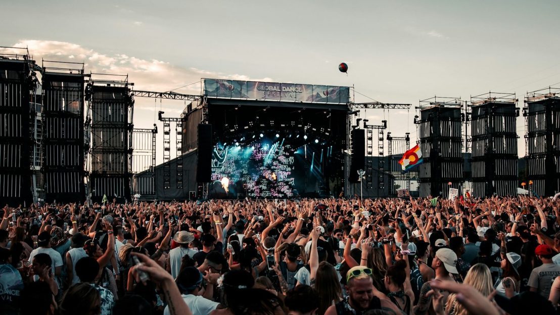 Une photo de la foule lors d'un festival de musique avec la scène en arrière-plan